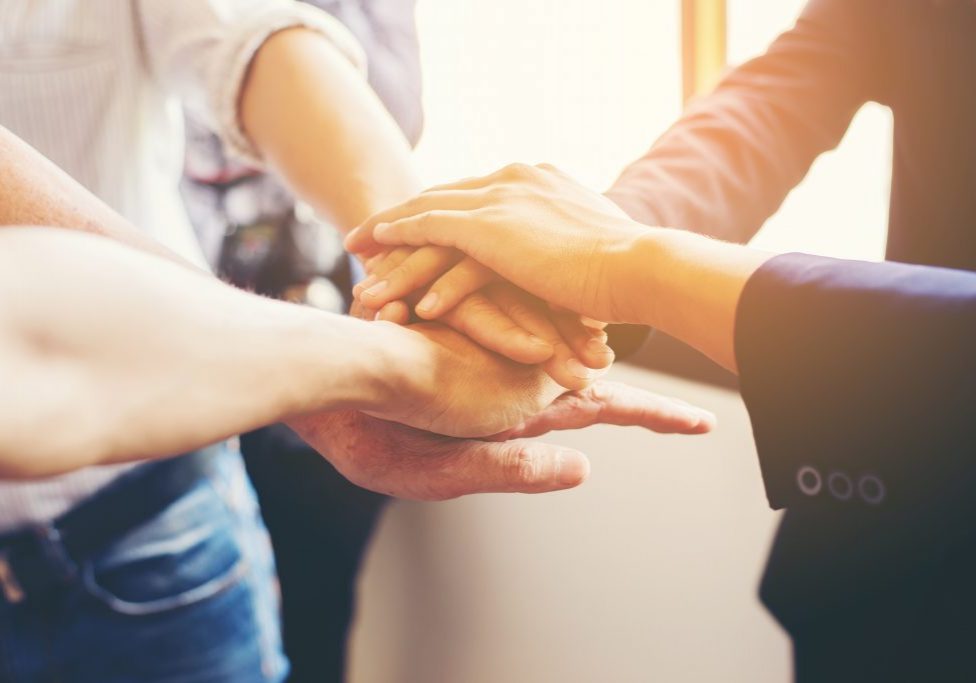Concept of teamwork: Close-Up of hands business team showing un Concept of teamwork: Close-Up of hands business team showing unity with putting their hands together.